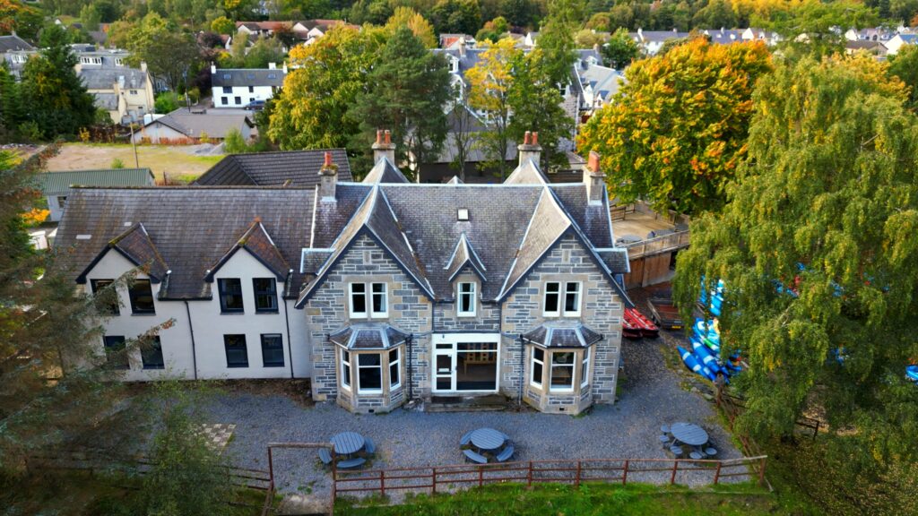 Image of Craigower Lodge taken from above, including gardens and watersports equipment.
