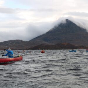 A group of people canoeing with mountains in the background as part of their Gold DofE award.